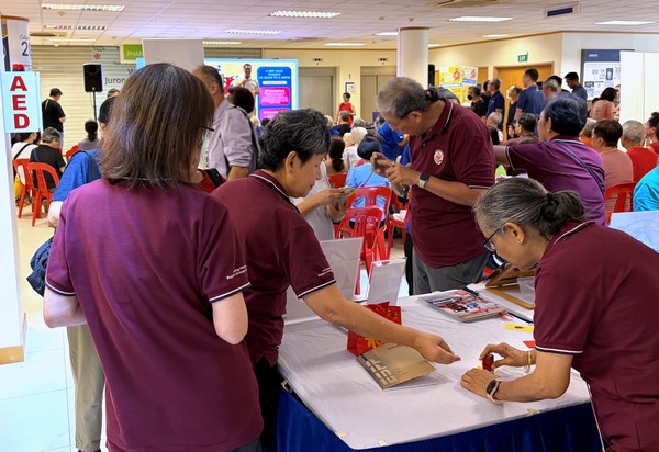 Heart support group volunteers welcoming residents at the NUHCS World Heart Health event, held at Jurong Medical Centre on 6 September 2026.